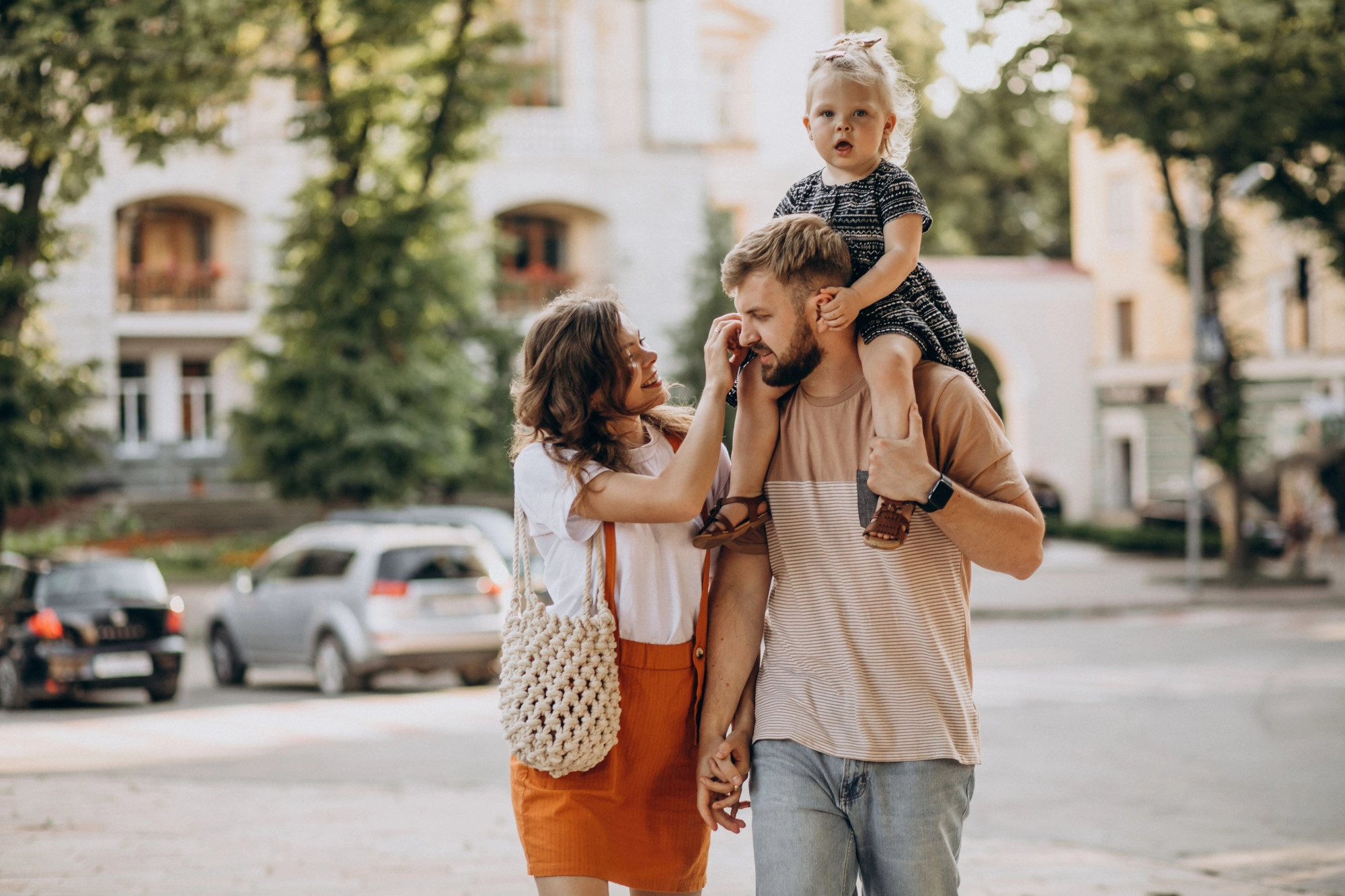 Persone che camminano in città con bambino sulle spalle, turismo familiare vicino al Titian Inn Hotel Treviso